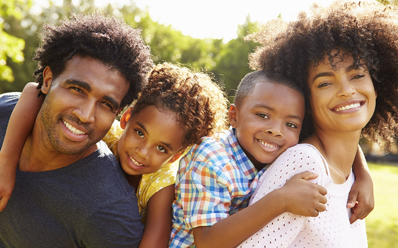 parents-giving-children-piggyback-rides-in-the-park